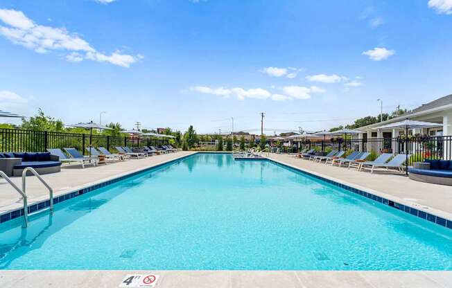 A large swimming pool with a blue water and a sign on the ground.