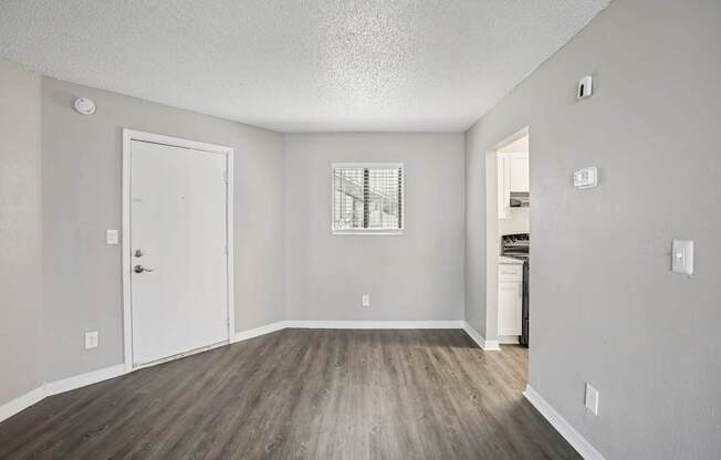 A room with a white door and a window with bars on it.