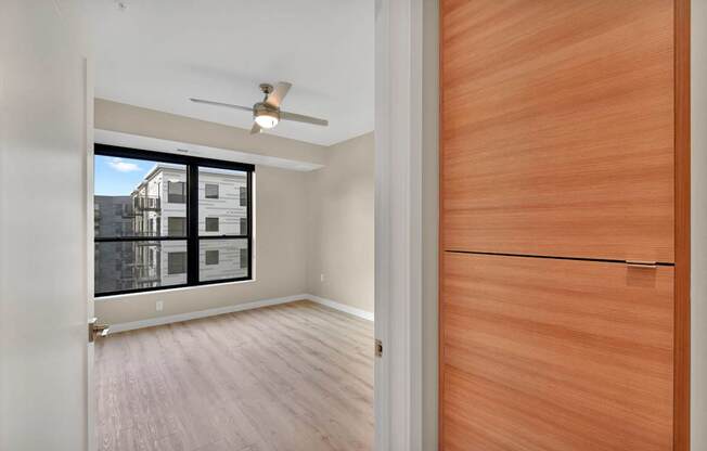A room with a ceiling fan and a wooden door.