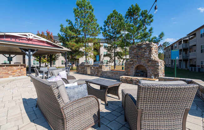 A patio with a fireplace and chairs.