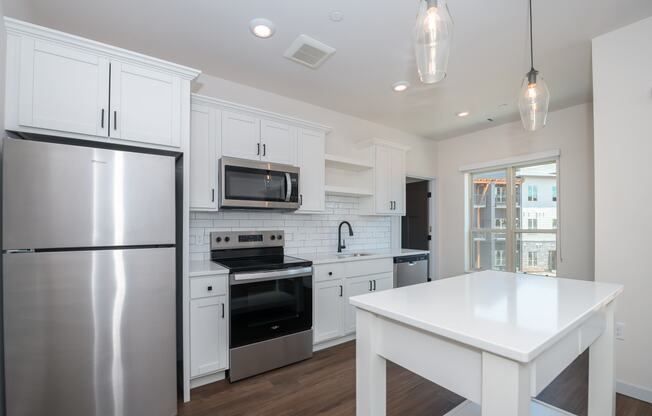 a renovated kitchen with white cabinets and stainless steel appliances at The Crossings at Windsong, Arizona, 86314