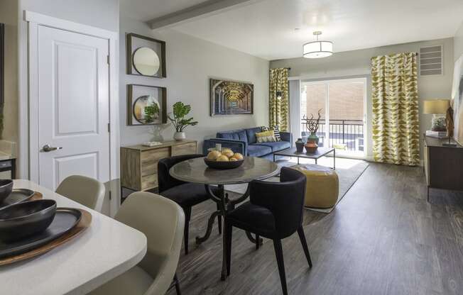 a furnished living room and dining room with a table and chairs