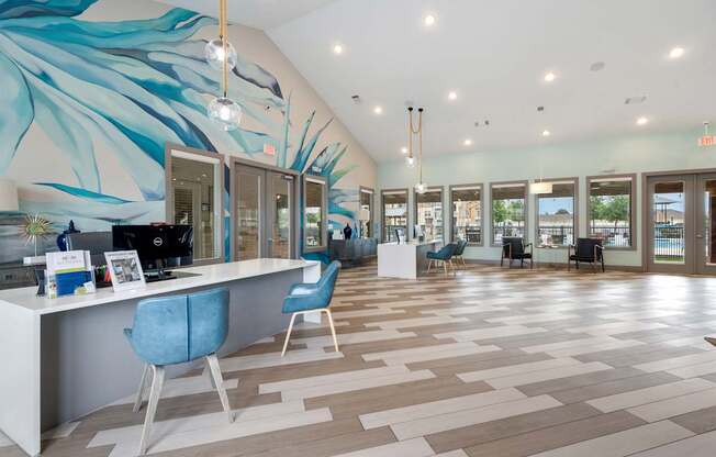 A reception area with a blue chair and a white desk.