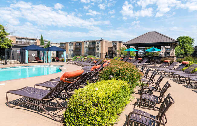A pool area with sun loungers and a gazebo.