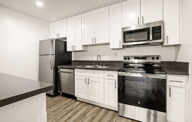 A kitchen with white cabinets and stainless steel appliances.