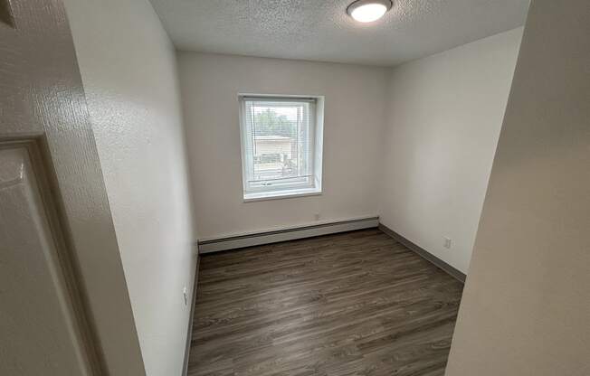 an empty bedroom with wood flooring and a window at Kings Court, Alaska, 99501?