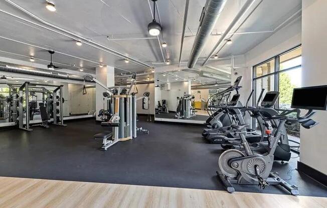 A spacious gym with a variety of equipment including treadmills, weights, and exercise machines.
