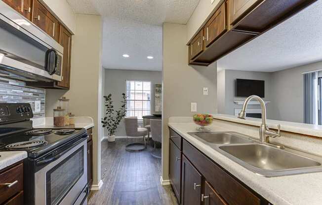 A kitchen with a black stove top oven and wooden cabinets.