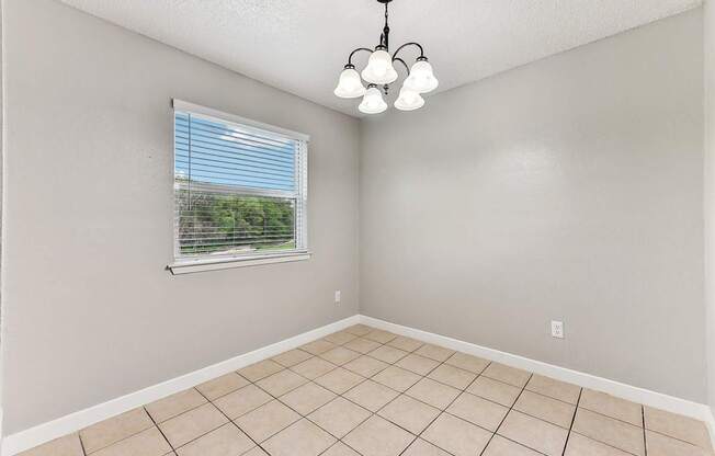 A room with a window and a chandelier.