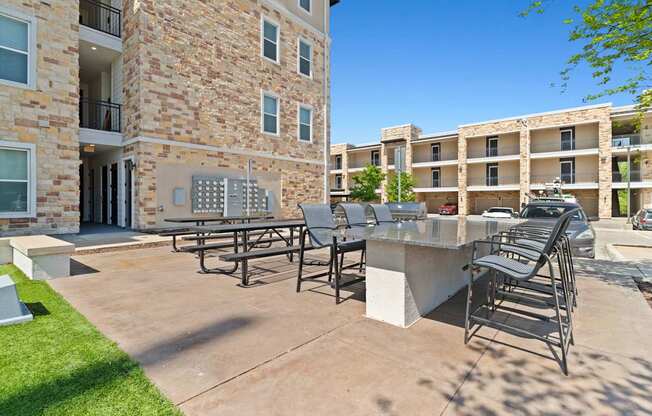 A patio with chairs and a table in front of a building.