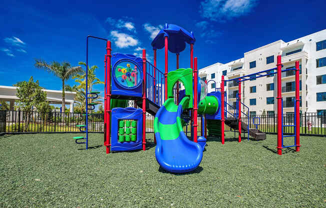 a playground with a slide and other play equipment in front of a building at Altis Santa Barbara, Naples, 34104