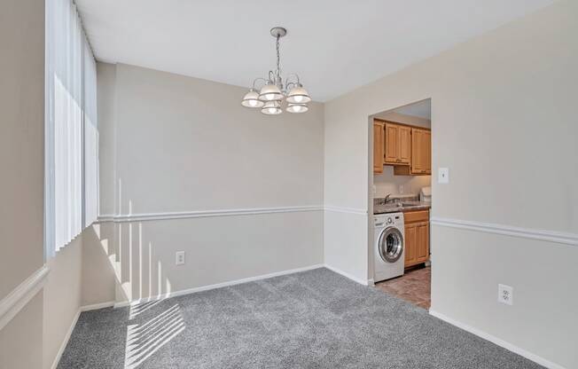 an empty living room with a laundry room and a washer and dryer