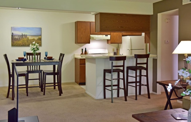 an open kitchen and dining area with a dining table and chairs at Beacon Hill and Great Oaks Apartments, Rockford, IL