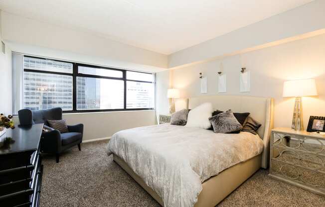 a bedroom with a large bed and a large window at Apartments at Denver Place, Denver, CO 80202