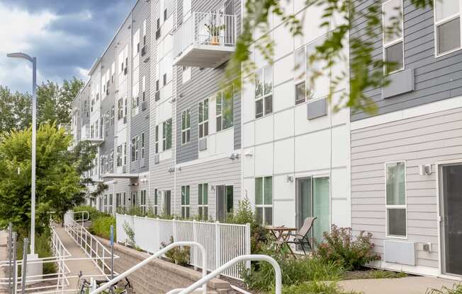 a large white apartment building with stairs and a fence