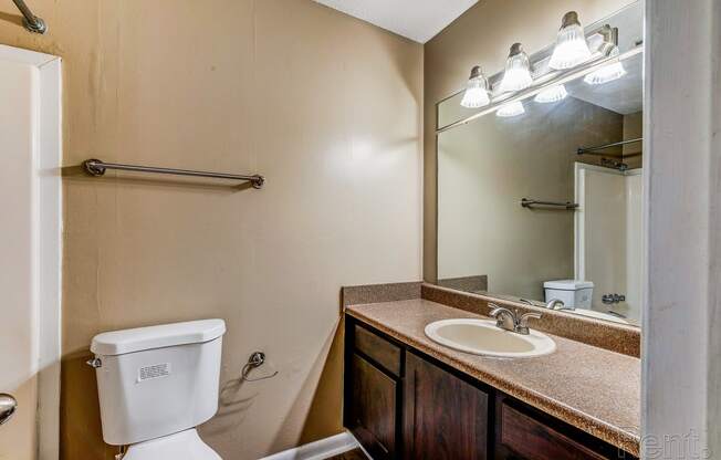 a bathroom with a sink toilet and a mirror