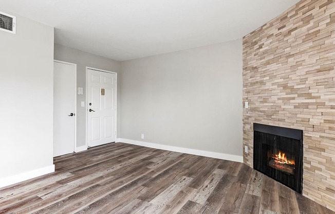 Hardwood floored living room with stone accented fireplace.