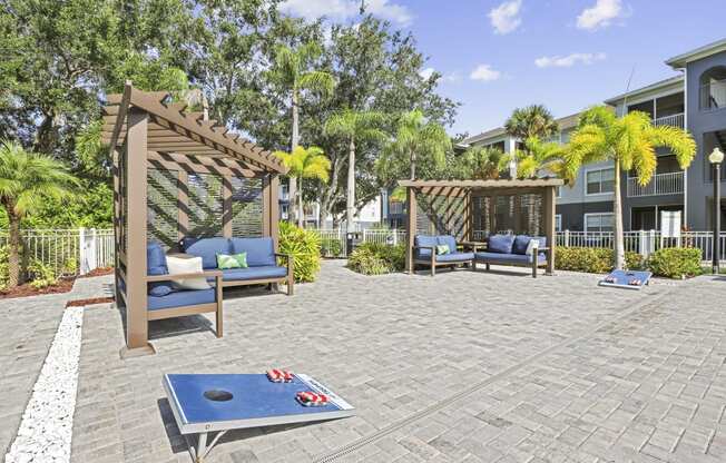 a patio with a blue ping pong table and a wooden gazebo