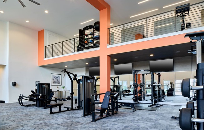 A gym with a variety of equipment including weights and cardio machines.