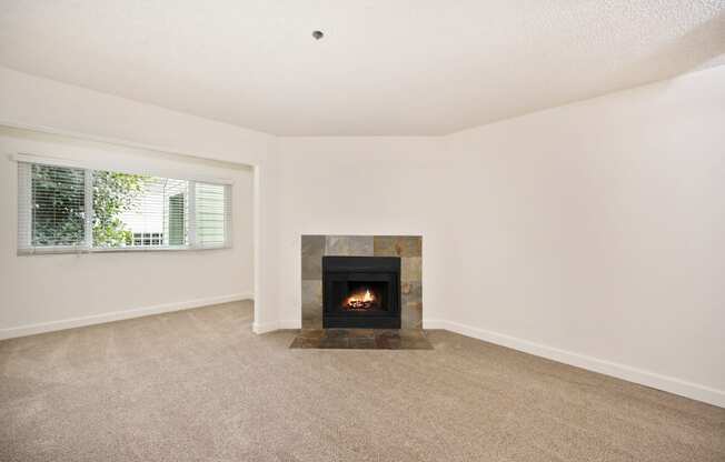 an empty living room with a fireplace and a window