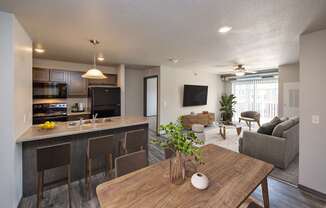 A modern kitchen with a bar and a dining table.