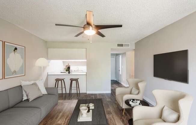 Model Living Room with TV and View of Kitchen at Indigo Park Apartments in Albuquerque, NM.