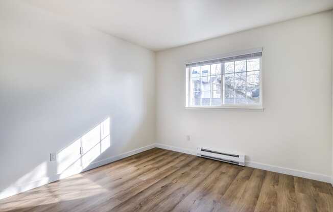 Apartments for Rent in Everett Washington - Woodbrook - Empty Bedroom with Wood-Style Flooring and Window