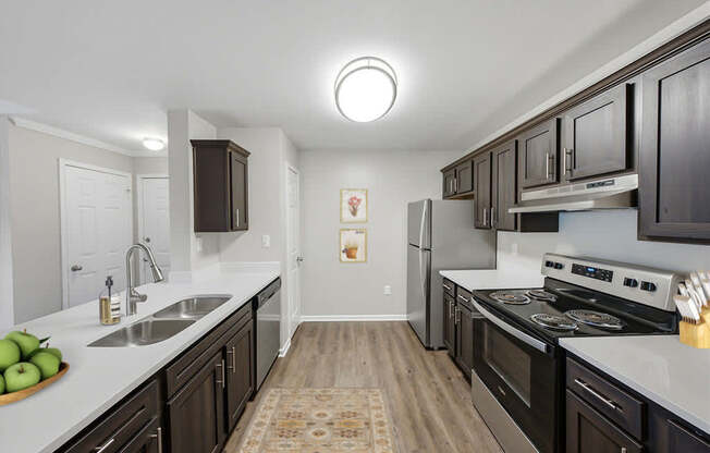 A kitchen with dark wood cabinets and a white countertop.