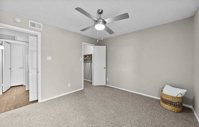 A room with a ceiling fan and a carpeted floor.