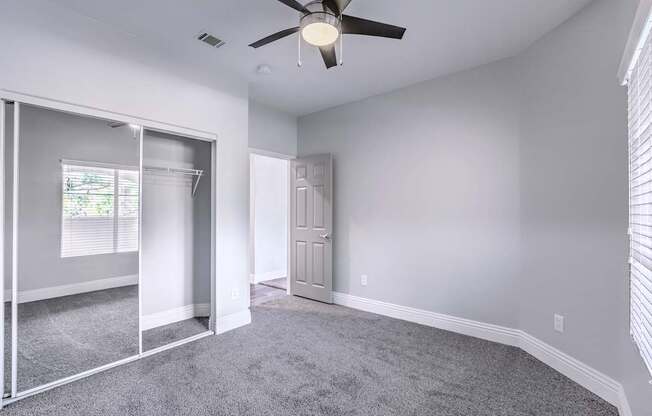 A room with a ceiling fan and a carpeted floor.