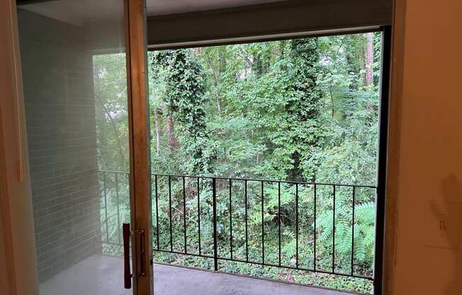 a room with a view of a balcony and trees