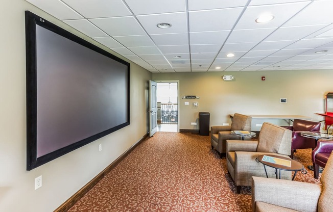 a room with couches and chairs and a television on the wall