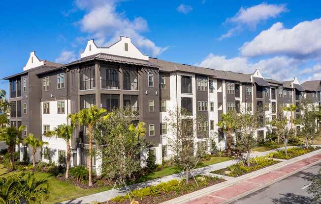 A large apartment complex with a red and white walkway in front.