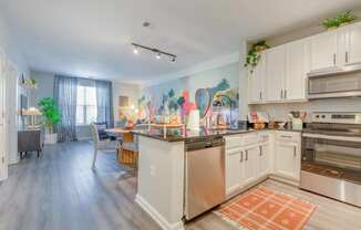 kitchen with white cabinets and stainless steel appliances at the bradley braddock road station apartments