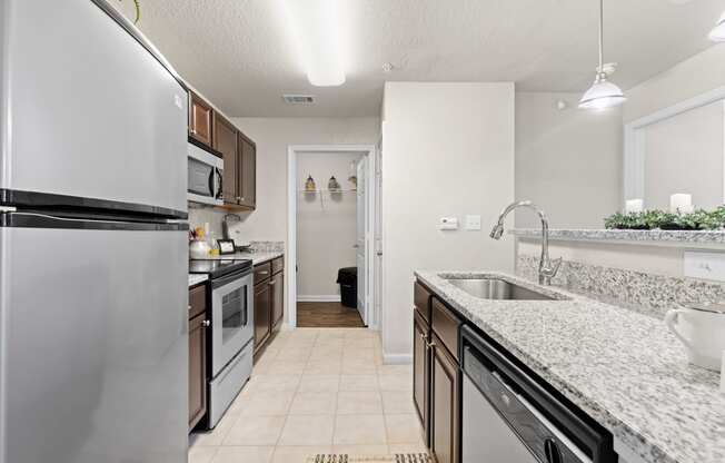 a kitchen with white granite countertops and stainless steel appliances