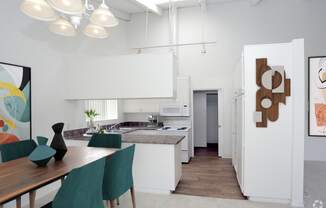 a kitchen and dining room with white cabinets and a table