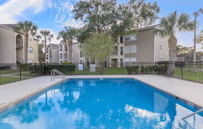 A swimming pool in front of apartment buildings.