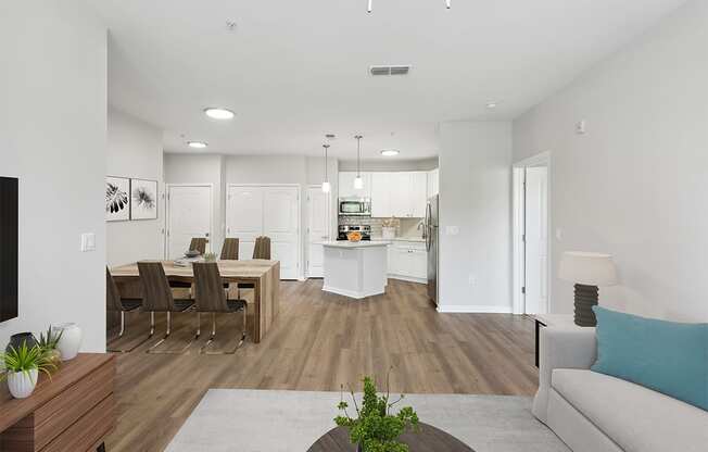 a living room and dining room with a kitchen in the background Two Addison Place, Pooler GA