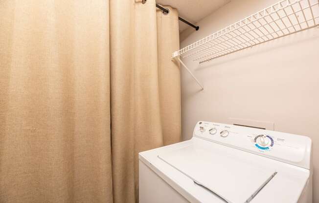 a washer and dryer in a laundry room with a shower