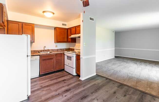an empty kitchen with wood floors and white appliances