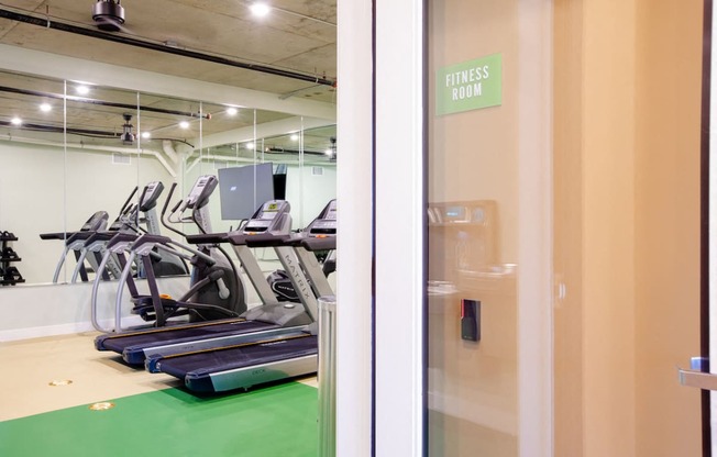 a gym with treadmills and a fitness room