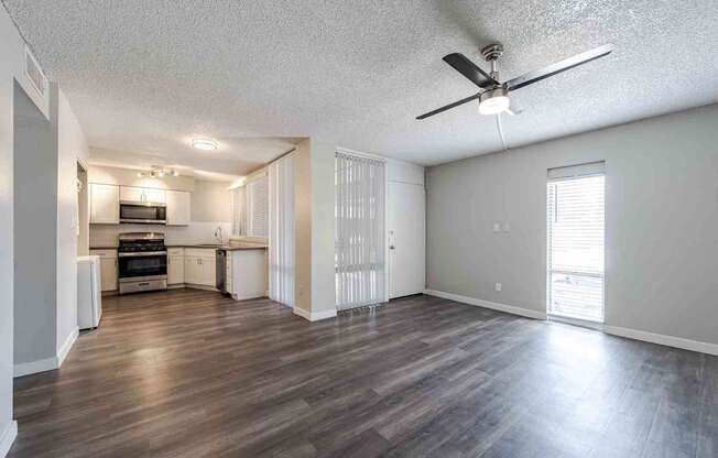 A spacious living room with a kitchen in the background.
