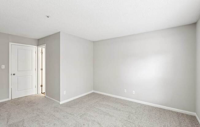 A room with a carpeted floor and a white door.