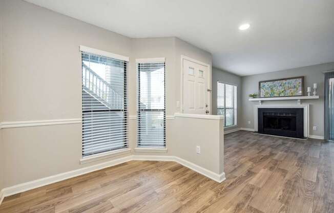 A spacious living room with a fireplace and a painting on the wall.