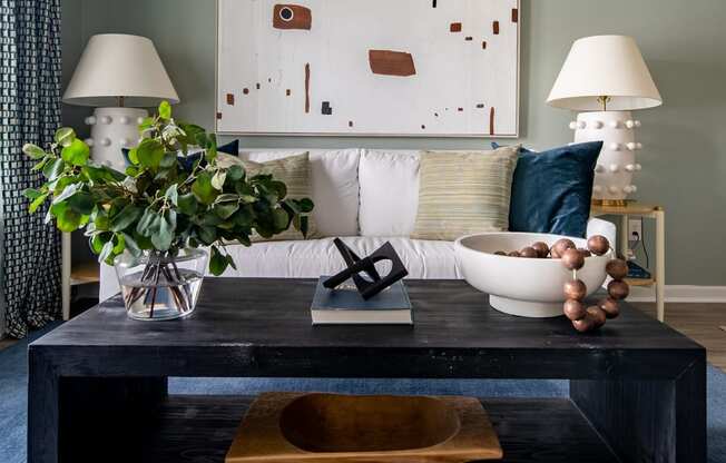 a living room with a coffee table and a painting on the wall