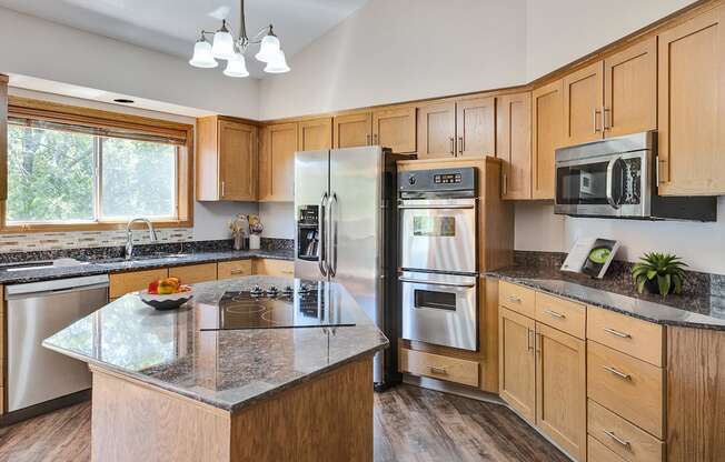 an updated kitchen with stainless steel appliances and granite counter tops