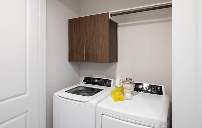A washing machine and dryer are in a small laundry room.