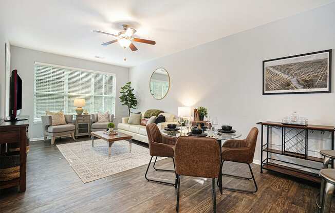 a living room with a dining table and a ceiling fan