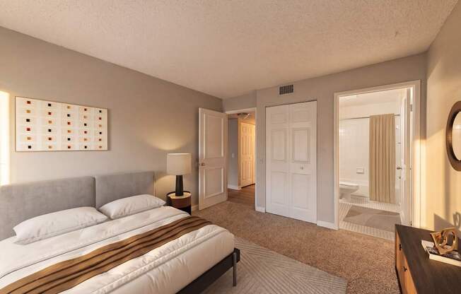 A bedroom with a large bed and a mirror on the wall.