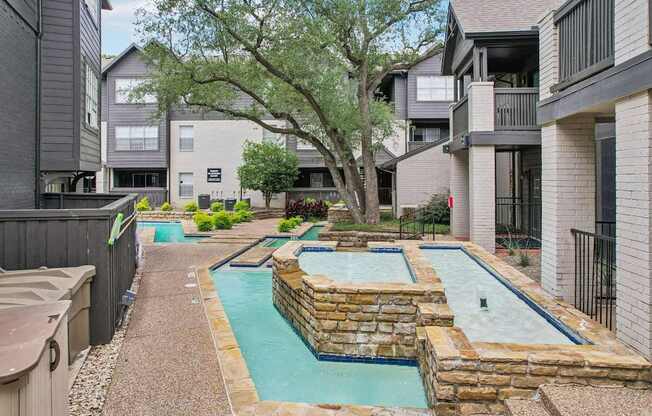 A small pool surrounded by a stone wall.